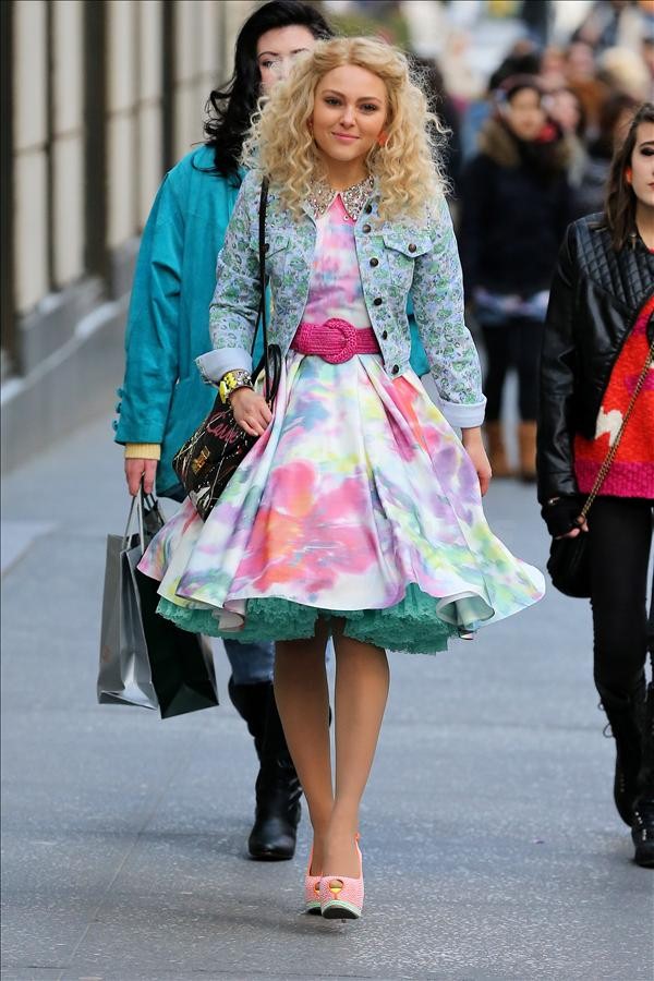 Actress Annasophia Robb, wearing a floral print dress with orange and yellow high heels, walks down Fifth Avenue filming The Carrie Diaries in New York City
